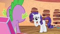 Rarity pondering about the fire ruby and looks adorable in the process.