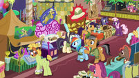 Quibble pointing at a convention booth S6E13