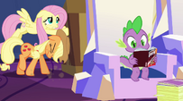 AJ and Fluttershy pushing a box while Spike reads a Daring Do novel EG2