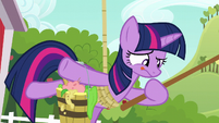 Twilight hangs from a rope while holding bucket and fishing rod S6E10