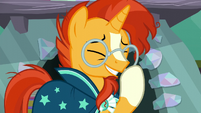 Sunburst adjusts his glasses while smiling S6E2