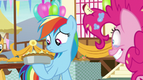 Rainbow Dash looks at the pie in her hoof S7E23