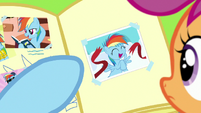 Rainbow points to picture of herself finishing a race S7E7