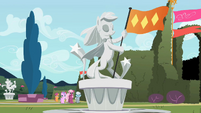 Statue of a pony holding a flag S2E01