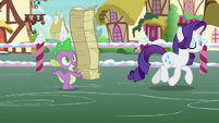 Spike holding restacked flyers; Rarity trots away S7E9