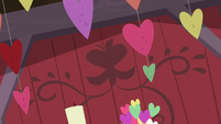 Strings of hearts hanging in the barn S8E10