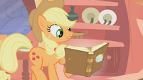 Applejack looking as if she'd never seen a book before.