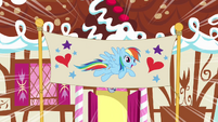 Rainbow Dash in front of birthday banner S4E12