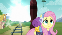 Fluttershy smiling while something appears in the distance S6E17