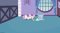 Sweetie Belle scrubbing the floor with a brush.