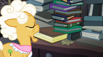 Goldie pulling a book from the tower of books S4E09