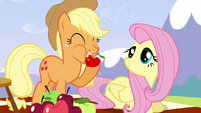 Applejack eating a red apple.