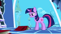 Twilight frowning at a book on the floor S1E01
