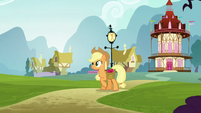 Applejack walking while carrying a bag of apples S5E19