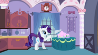 Rarity tosses a cloth onto a pile of cloths in a basket.