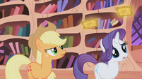 Applejack and Rarity watching the two floating tickets.