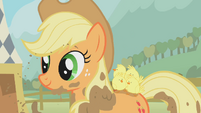 Applejack, smiling with baby chicks on her back.