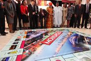 Lagos state governor, Babatunde Raji Fasholarolls (center), rolls dice during the presentation of the Lagos-themed Monopoly board game.