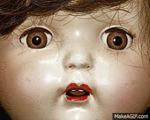 A possessed doll turning her head at a girl who scares her