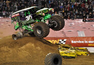 Grave Digger (with 30th Anniversary deco in 2012) loses a right-back tire, leaving only the rim.