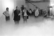 On set of Missing Link. L-R: Ray Austin, Frank Watts (smoking), Alac Meacham (in front of boom stand), and Terry Schubert (sitting on the dry ice machine).