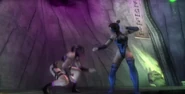 Kitana combate Mileena diante dos shaolins