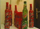 Photograph of Iraqi bottles and cans of regular Mountain Dew and Mountain Dew Code Red, showing both their English and Arabic language sides.