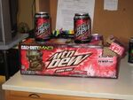 A photograph of an opened Game Fuel (Citrus Cherry) 12-pack box with two cans of Game Fuel (Citrus Cherry) on it.