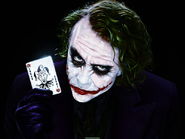The Joker holds his card