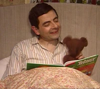 Bean reading a book with teddy