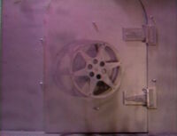 Pink-lit safe that flips open to the right when opening, leading to the theater, and to the left when closing. Note: This door shows a mouse zipping by on the floor when opening.