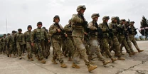 Modern day American Soldiers marching in formation carrying M4 assault rifles, wearing body armour, and the Army Combat Uniform (ACU).