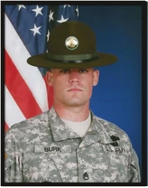 Former American Army Infantryman, Drill Sergeant, and current Army Instructor, John Burk, wearing a campaign hat, and the Army Combat Uniform in Universal Camouflage Pattern.