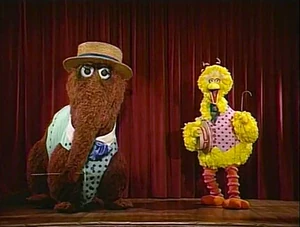 Big Bird and Snuffy, live on stage introducing educational concepts.