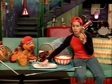 Niki and Tingo eat hot dogs while watching a baseball game in Sesame English "A Home Run for Niki."