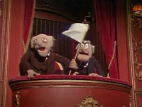 Statler and Waldorf wave a flag of surrender when a member of The Teeterini Family comes flying into their box in The Muppet Show episode 512