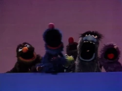 A gaggle of monsters "assist" Kermit with his song.