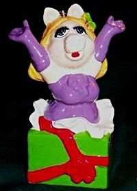 Miss Piggy popping out of present