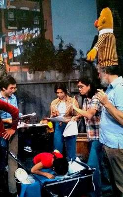 Behind the scenes, director Jon Stone fancies the Bert puppet as a hat.