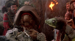 Mudwell holding Dead Tom in Muppet Treasure Island