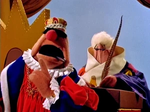 King Goshposh dictates his invitation to the masked ball: "Bring a present for the King