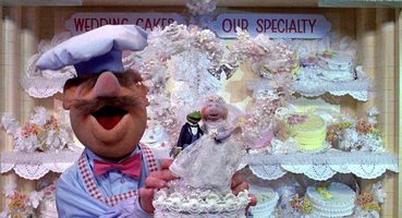 The Muppets Take Manhattan: The Swedish Chef places Kermit and Piggy's wedding topper.