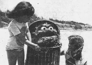 Locals Chelsea Woods and Kelly Swartman present Oscar with a lei made of trash.