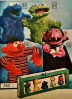 photo from a Canadian catalog showing Count (sans monocle and with cape) with the Topper Ernie, Oscar and Cookie Monster puppets, and a prototype Child Guidance finger puppet gift set