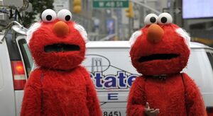 Two mascots of Elmo with grey hair.