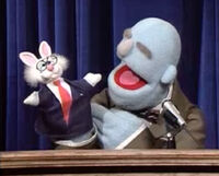 A speaker uses "Mr. Business Bunny" to get his audience's attention in a Muppet meeting film "Top Ten Reasons to Take a Break."