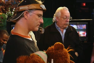 Puppeteer  and camera operator  watch a playback.