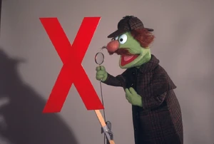 Sherlock poses with the letter X in an alternate shot for the cover of the song's 1976 audio release. Note in this uncropped version the duct tape used to keep Sherlock in his pose.