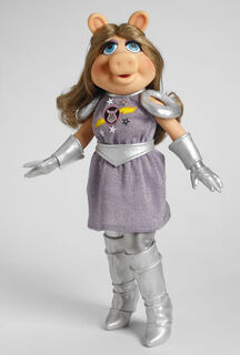 First Mate Piggy Dressed in her famous Pigs in Space outfit (including appliquéd stars and the embroidered logo) with silver gloves, silver tights, silver zip-up boots, a silver faux leather belt and a golden brown-blonde wig. 16" tall. Limited edition of 1000 pieces.