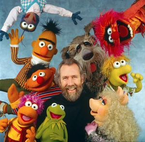 Jim Henson surrounded by Muppets Fraggles Sesame